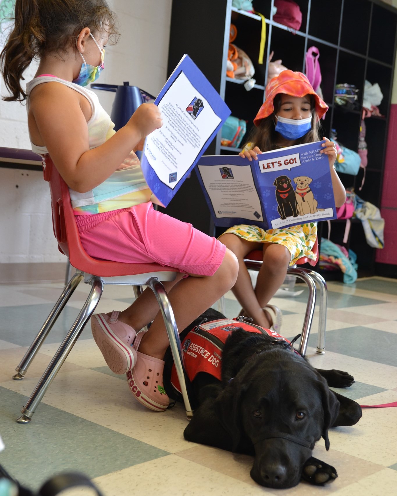 two childen read to a dog