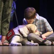 (042918 Fitchburg, MA) Derek Blake, 9 1/2 kisses his social dog Jean during NEADS service dog graduation ceremony in Fitchburg on Sunday,April 29, 2018. Staff Photo by Nancy Lane